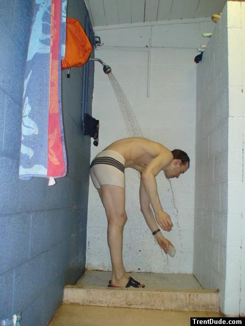 Reaching down for the soap dish in a speedo white suit (rear)