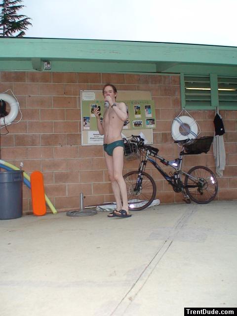 Standing near the bike in a Nike speedo