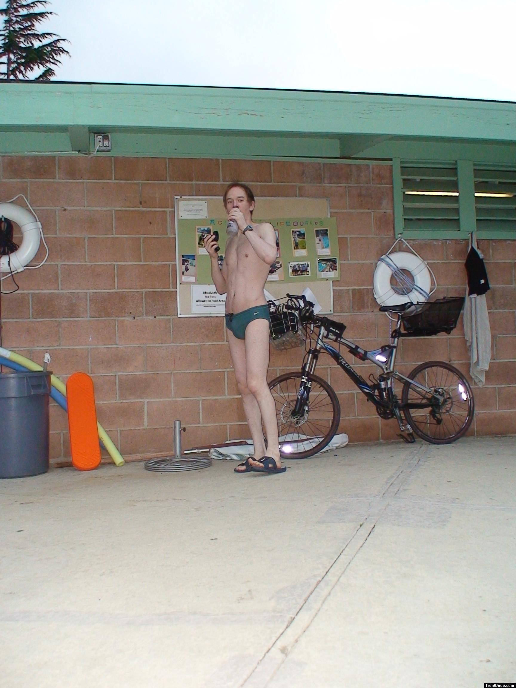 Standing near the bike in a Nike speedo