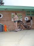 Standing near the bike in a Nike speedo