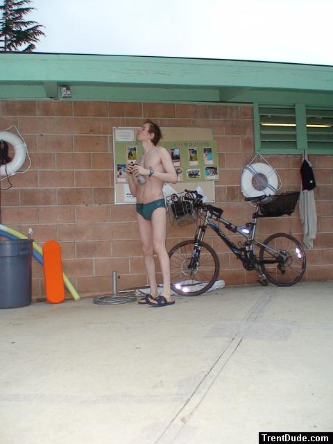 Standing near the bike in a Nike speedo