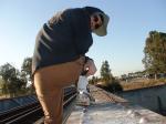 Brown sweats on train trestle (rear), Ascis Gel Evolution 3 shoe (TN7A2), Oregon Research Helios sun hat, Christian Dior Monsieu