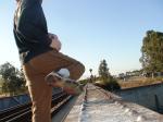 Brown sweats on train trestle (rear), Ascis Gel Evolution 3 shoe (TN7A2)