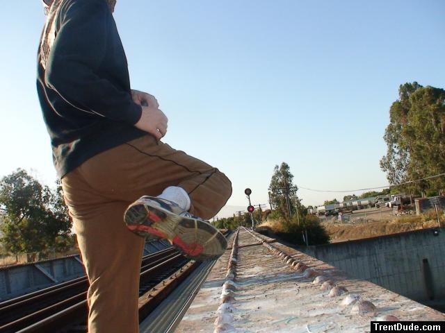 Brown sweats on train trestle (rear), Ascis Gel Evolution 3 shoe (TN7A2)