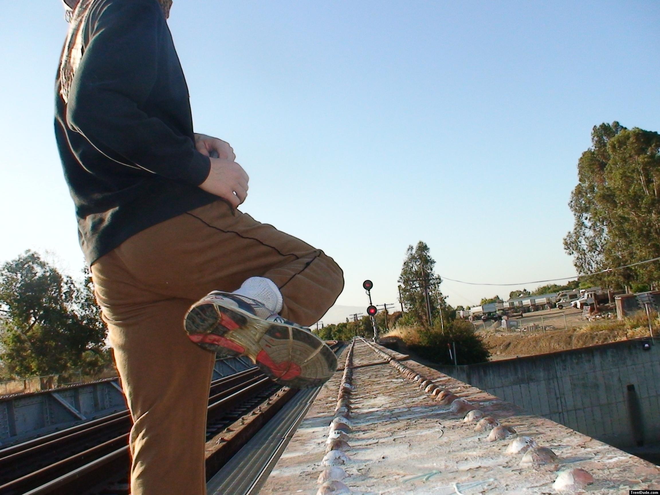 Brown sweats on train trestle (rear), Ascis Gel Evolution 3 shoe (TN7A2)
