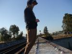 Brown sweats on train trestle, Oregon Research Helios sun hat, Christian Dior Monsieur Cashmere scarf
