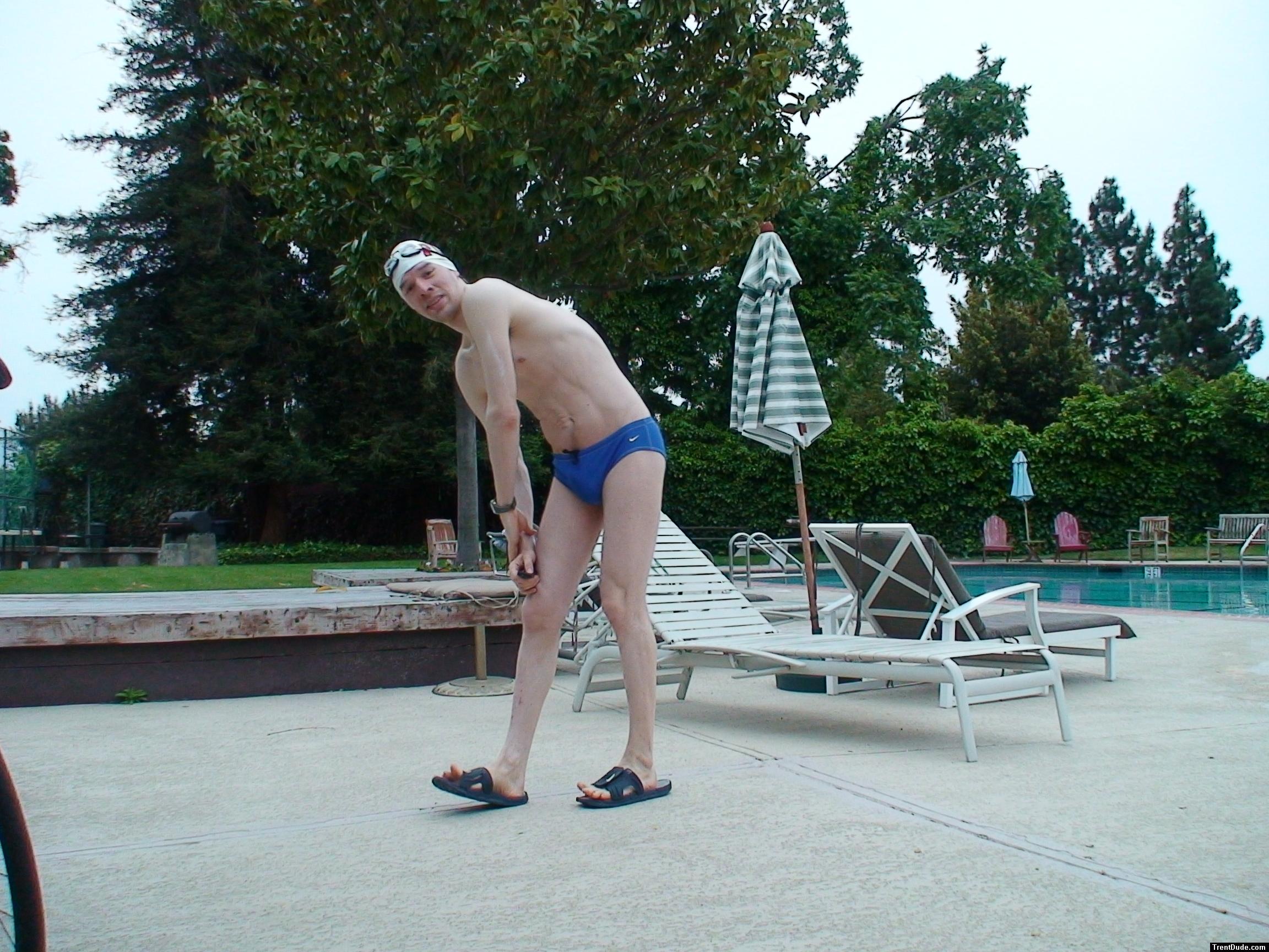 Blue Nike speedo, white swim cap (stretching)