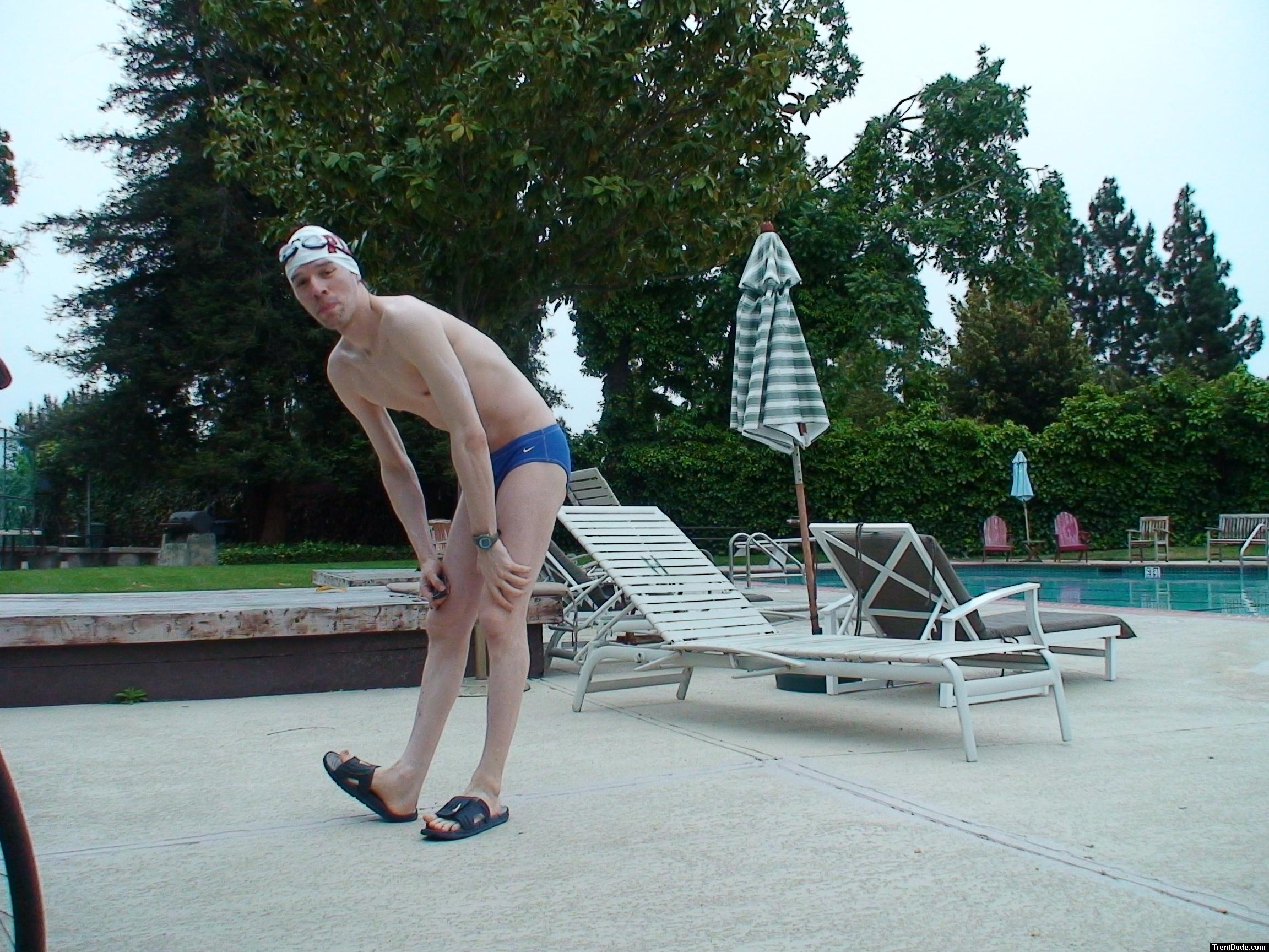 Blue Nike speedo, white swim cap (stretching)