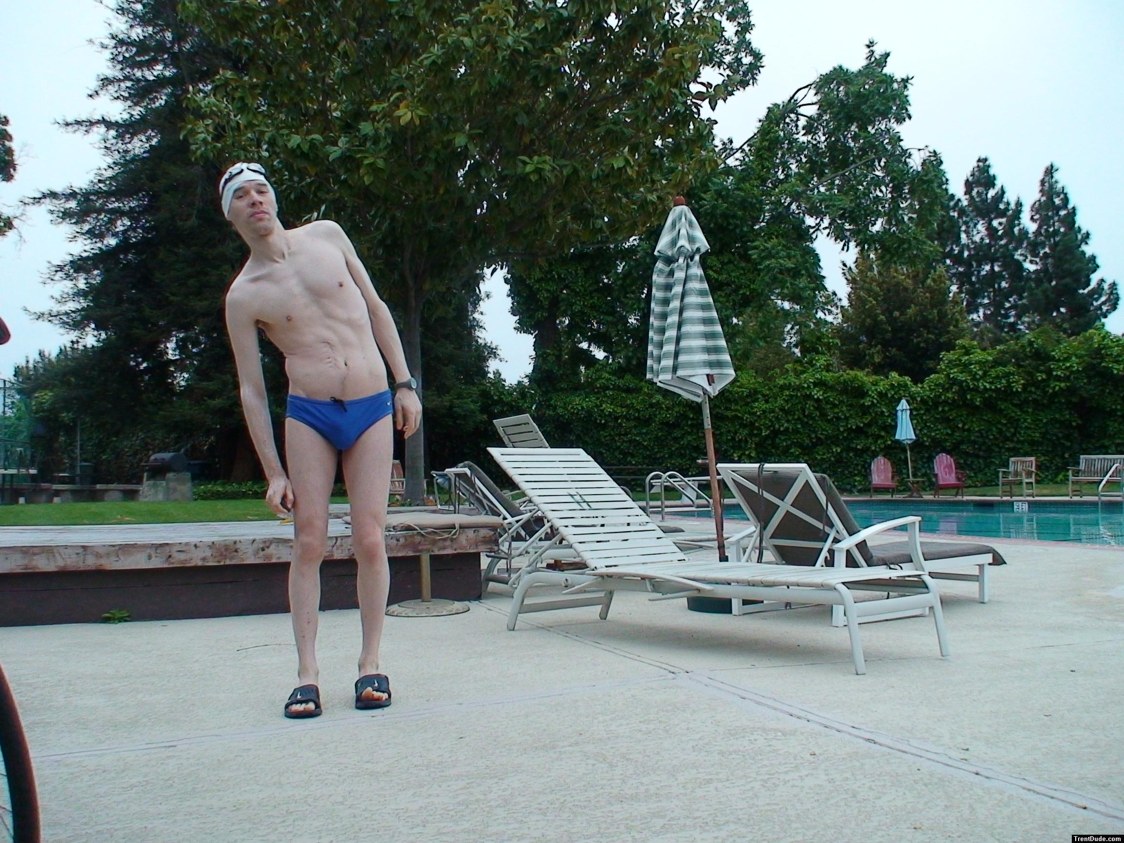 Blue Nike speedo, white swim cap (stretching)