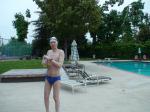 Blue Nike speedo, white swim cap (holding peanuts for the birds)