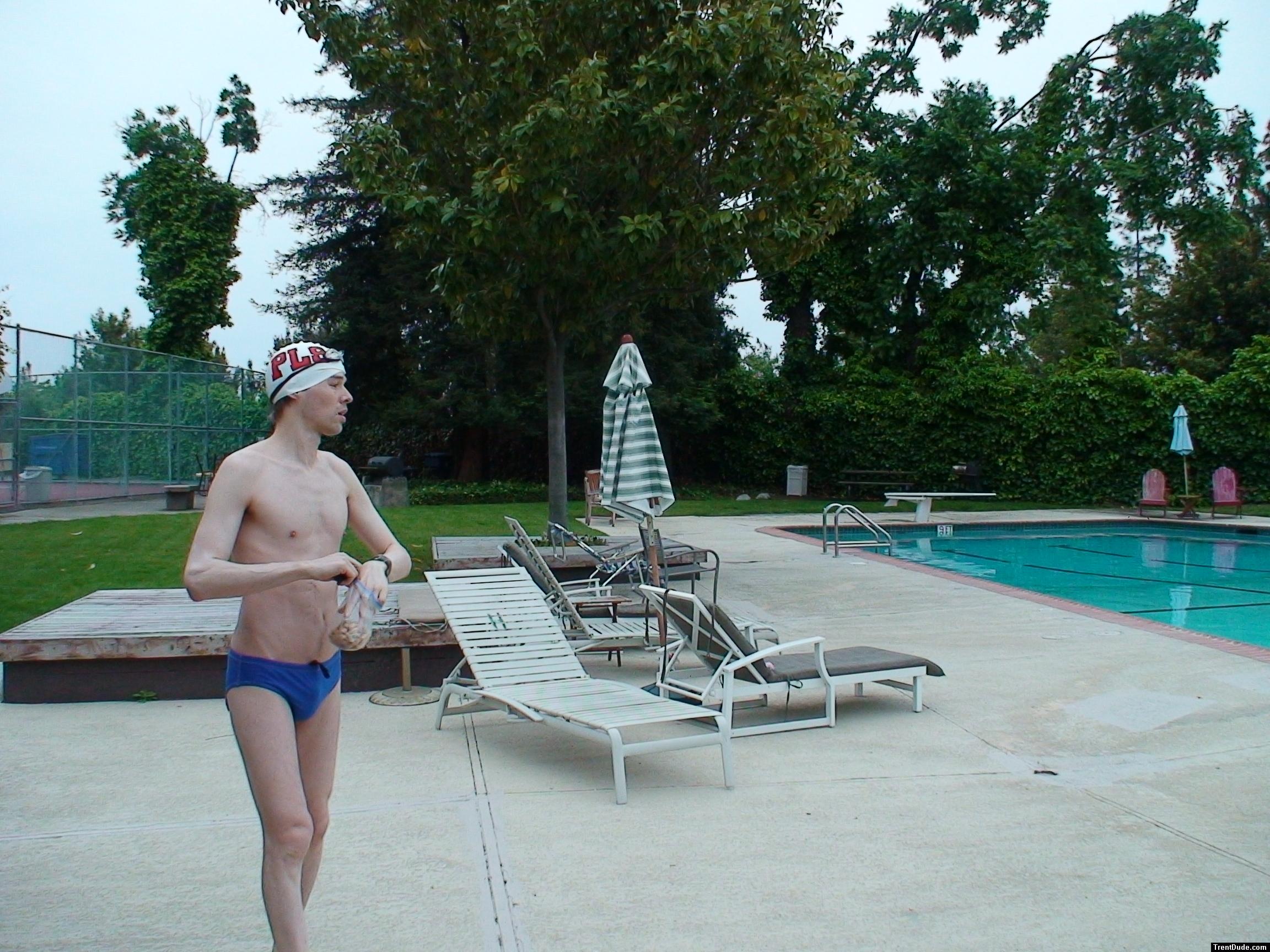 Blue Nike speedo, white swim cap (holding peanuts for the birds)