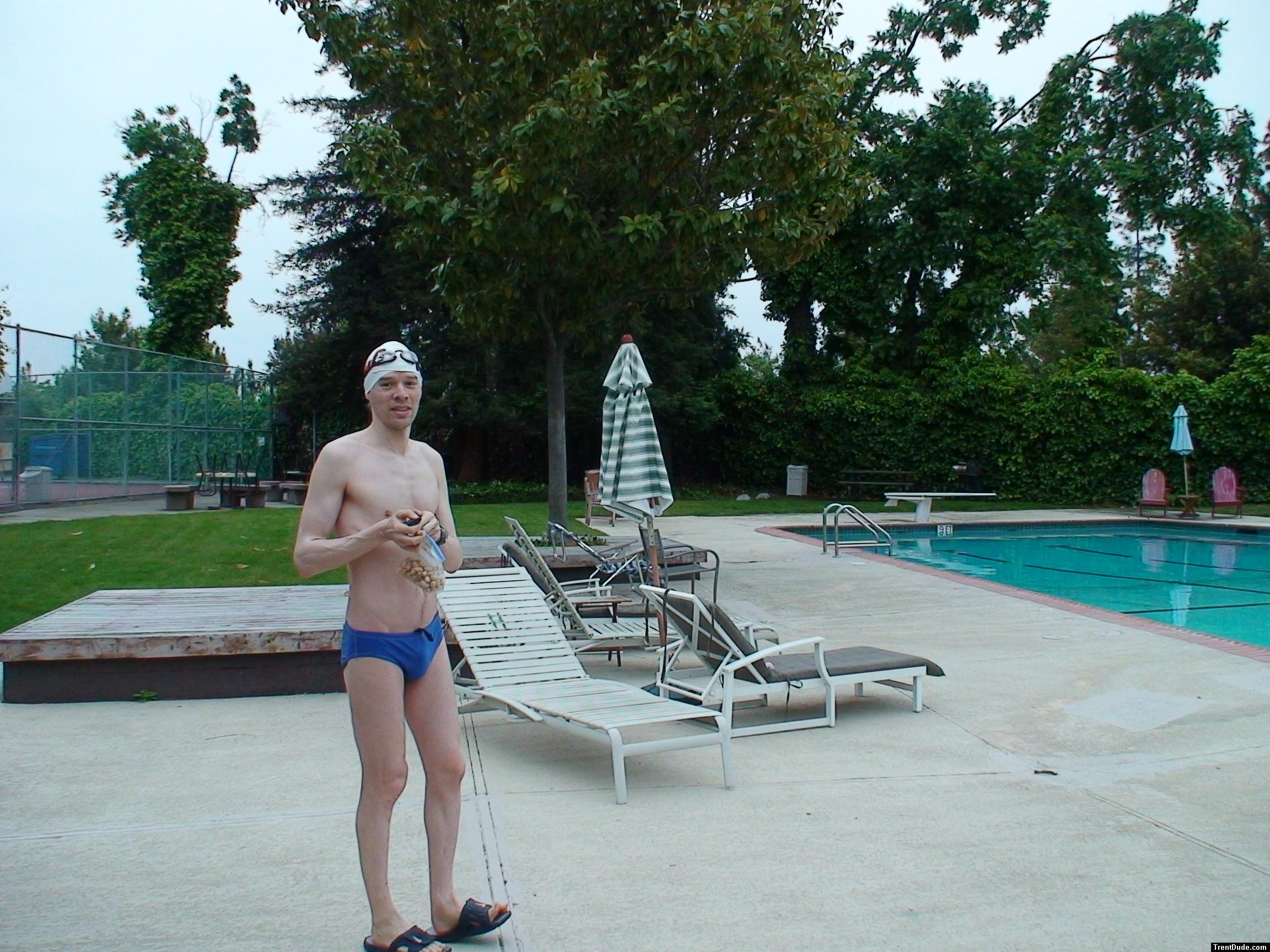 Blue Nike speedo, white swim cap (holding peanuts for the birds)