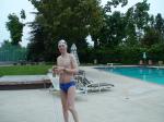 Blue Nike speedo, white swim cap (holding peanuts for the birds)