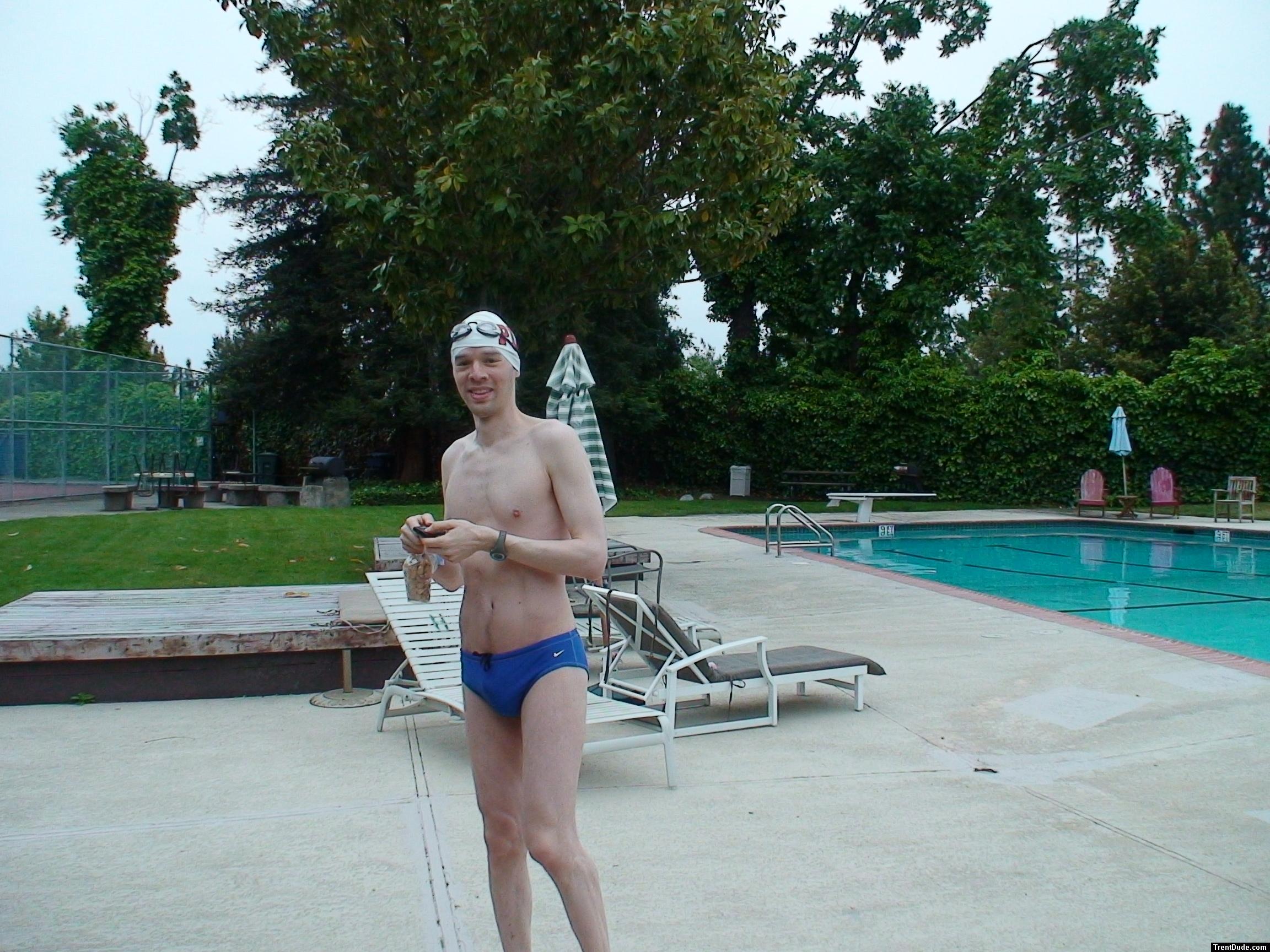 Blue Nike speedo, white swim cap (holding peanuts for the birds)