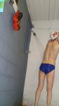 Showering in a white swim cap, blue nike speedo (rear)