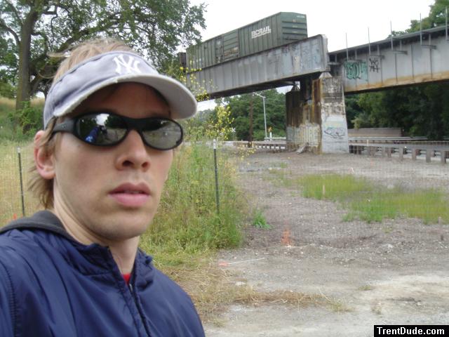 Trent near a train with black ray ban sunglasses