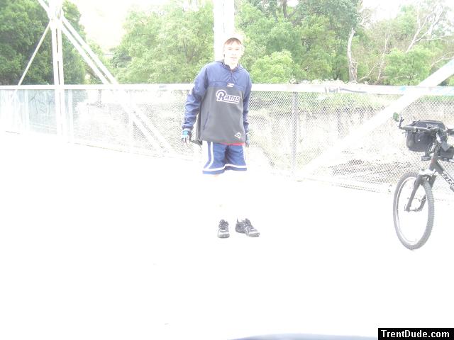 Trent on a bridge with bike wearing a Rams sweatshirt (for sale) and blue nylon shorts. Maybe its time to use adobe.
