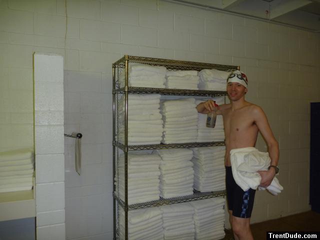 Nike swim jammer in the swim locker room, near some towels, drinking fruit smooothie before a swim