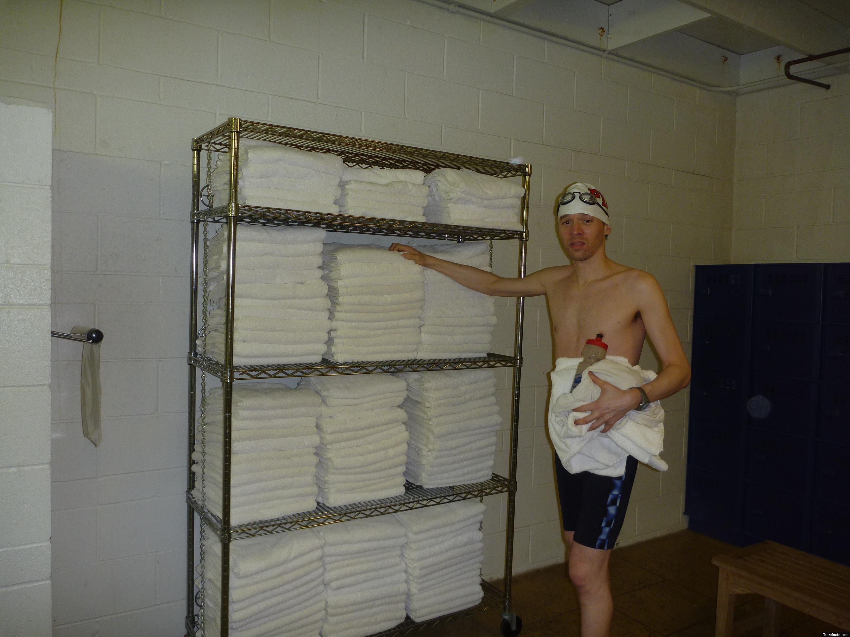 Nike swim jammer in the swim locker room, near some towels, drinking fruit smooothie before a swim