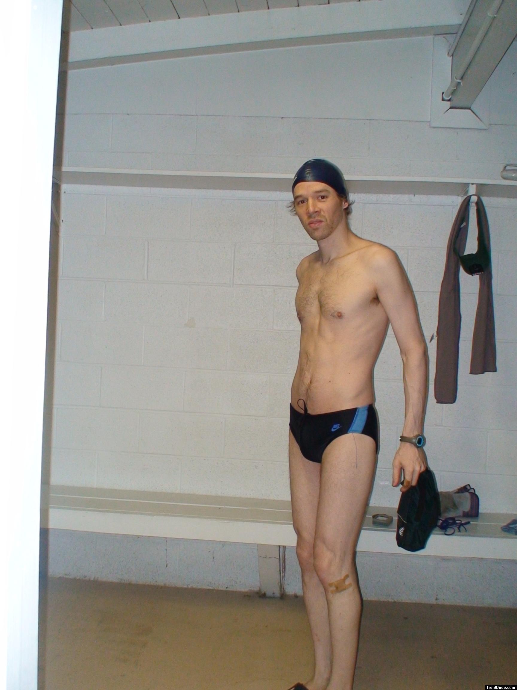 Standing in the swim locker room in a Nike black/blue swim brief