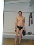 Standing in the swim locker room in a Nike black/blue swim brief