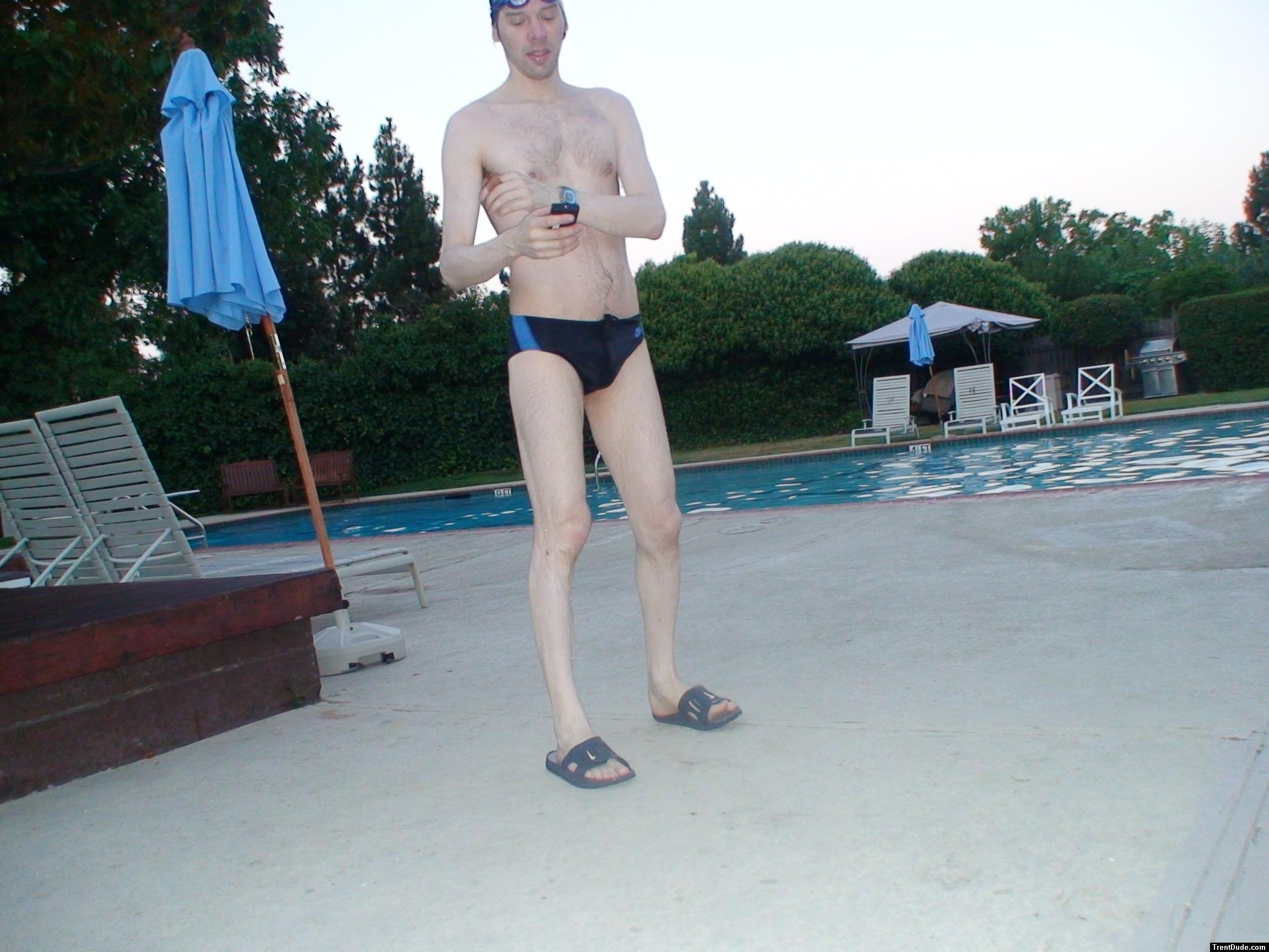 Nike black/blue swim brief, checking his cell phone