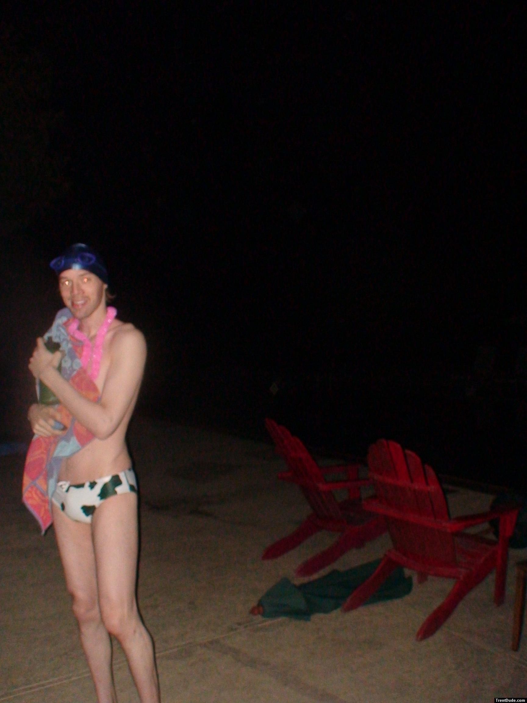 Holding a towel in a white/green cow print water polo swim brief