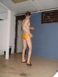Stretching in the locker room in a yellow speedo
