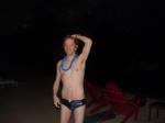 Navy blue swim team speedo with football, wearing blue lei