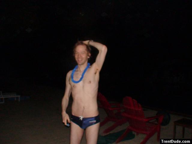 Navy blue swim team speedo with football, wearing blue lei
