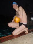 Swimmer in a speedo holding a water polo ball (feet)