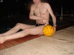 Swimmer in a speedo holding a water polo ball (feet)