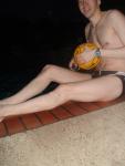 Swimmer in a speedo holding a water polo ball (feet)