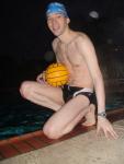 Swimmer in a speedo holding a water polo ball (feet)