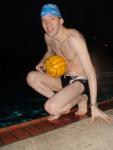 Swimmer in a speedo holding a water polo ball (feet)