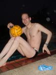 Next to the pool with a water polo ball (legs)