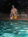 Sitting next to the pool, leg resting on ball