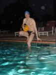 Swimmer in speedo, swim cap, with water polo ball