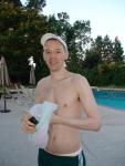 smiling with addidas shorts and white speedo underneath 