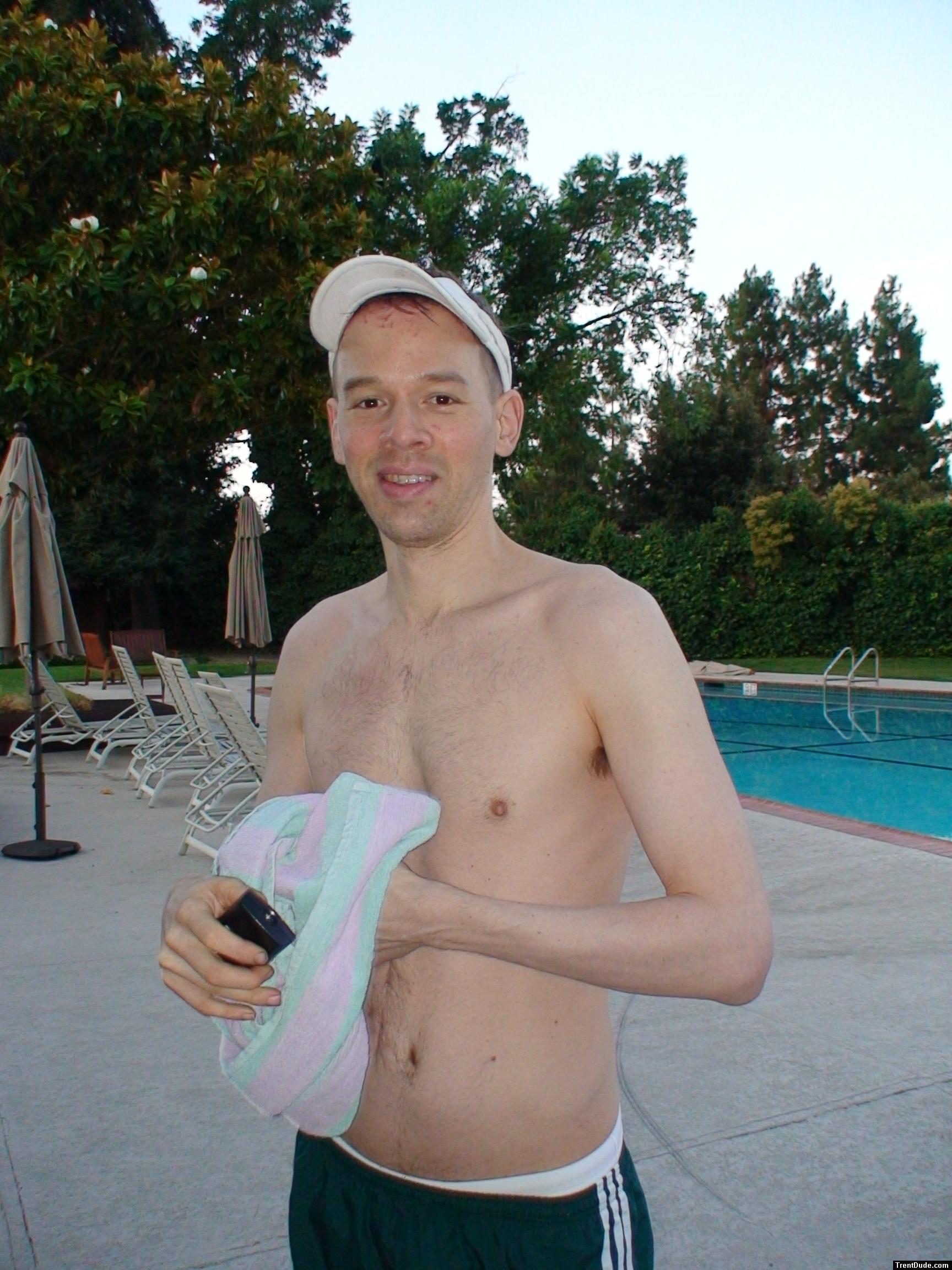 smiling with addidas shorts and white speedo underneath 