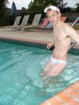 slipping into the pool in a white Speedo