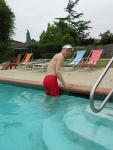 Climbing out of the pool in a red swim jammer