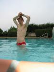 Showing his armpit in a red Speedo