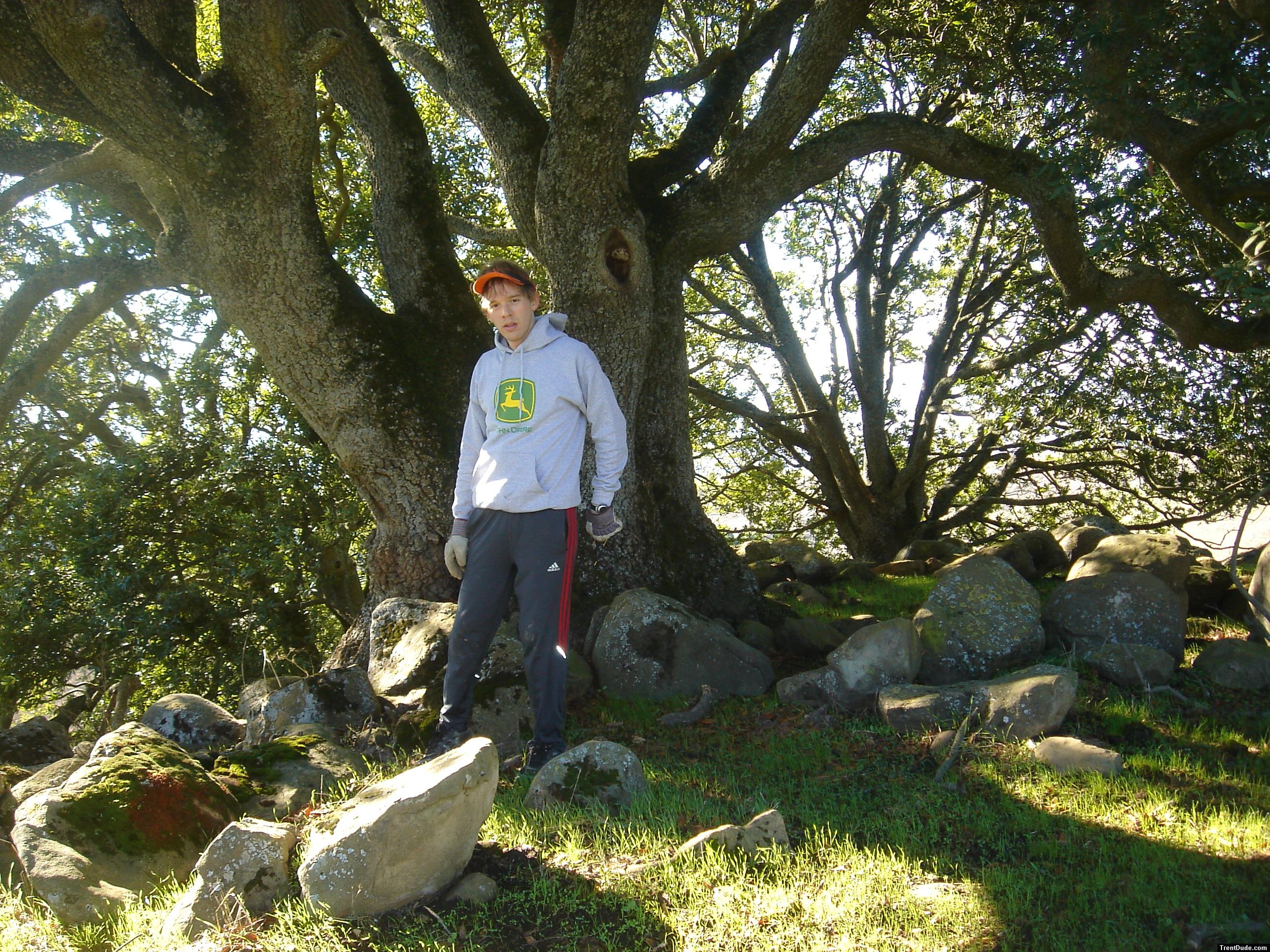 Trent by a secret tree (a favorite spot of his on the ranch), wearing a John Deere sweatshirt and Addidas nylon pants (for sale)