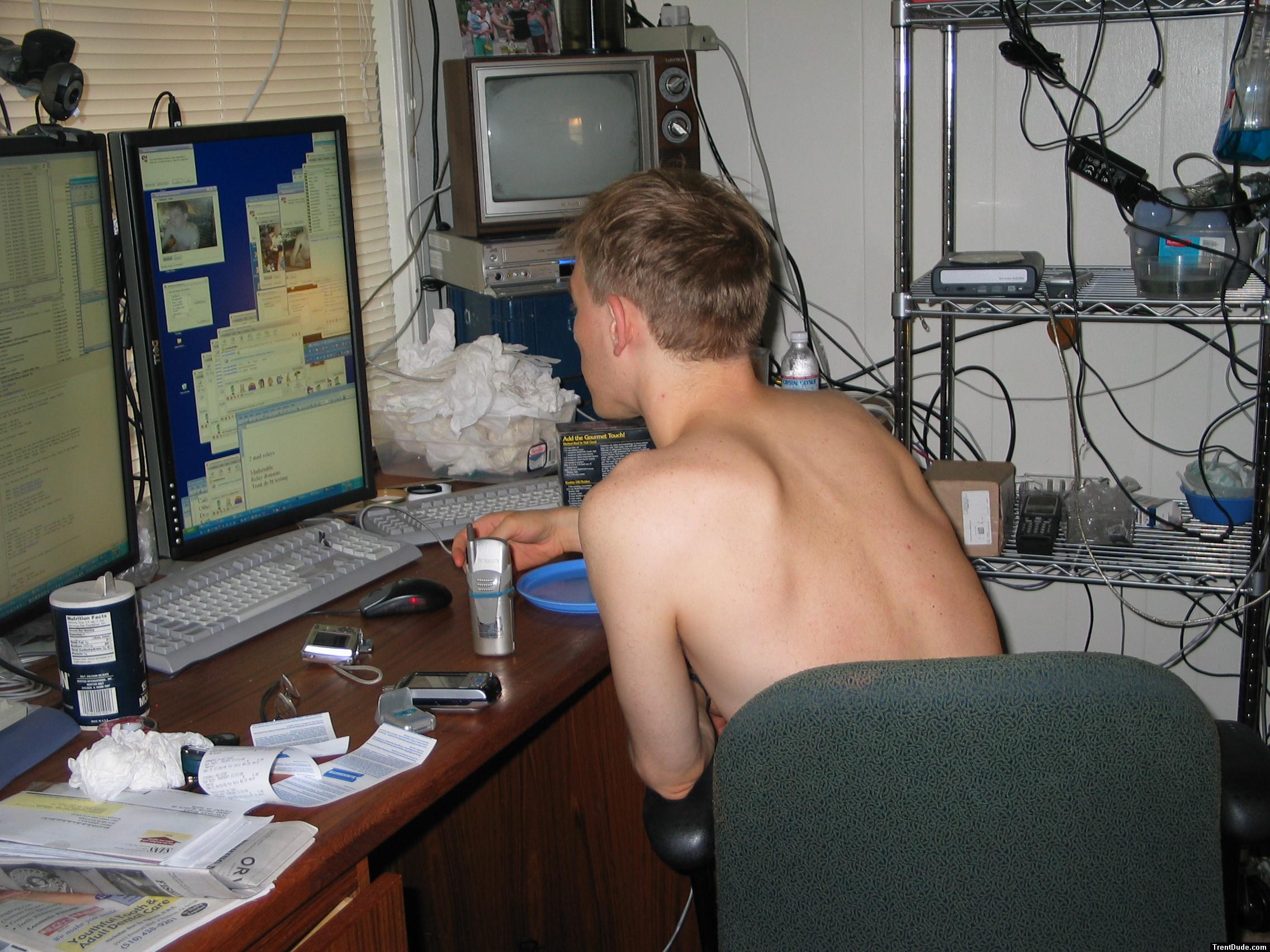 back, sitting in a chair at the computer