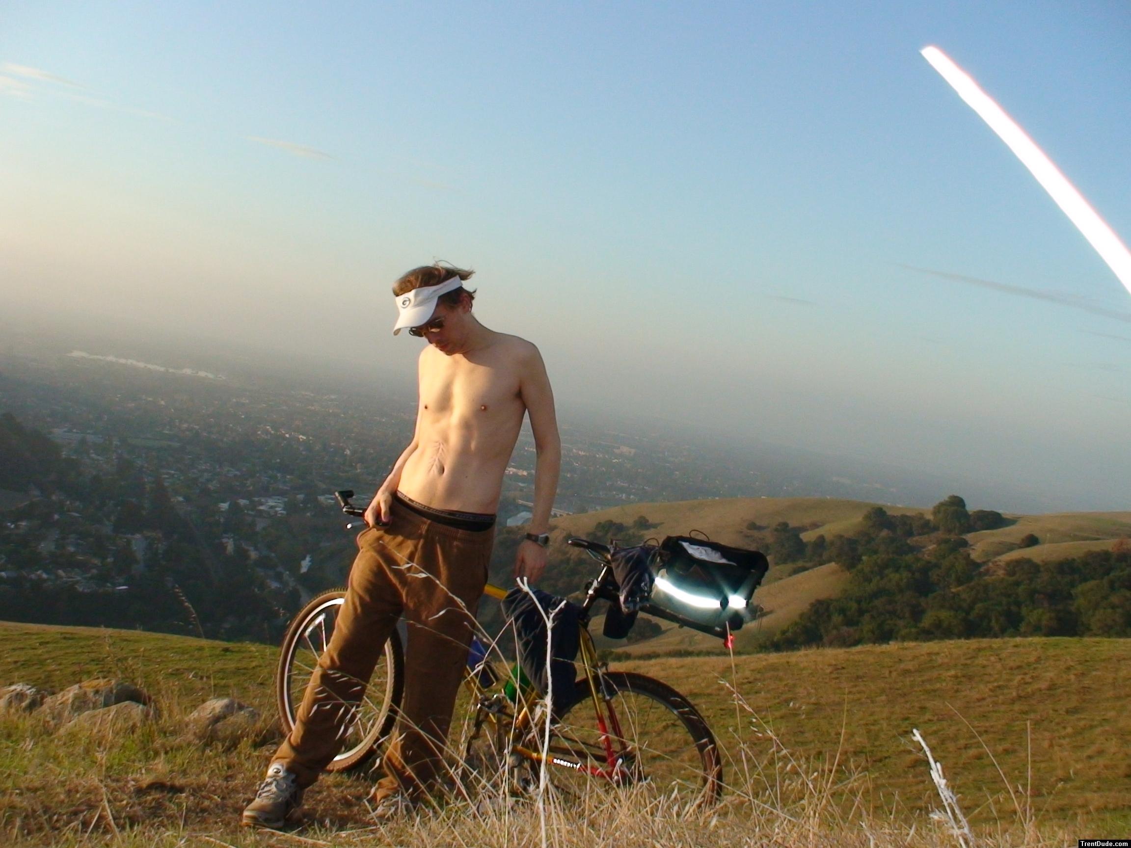 shirtless in Puma sweat pants and with the bike