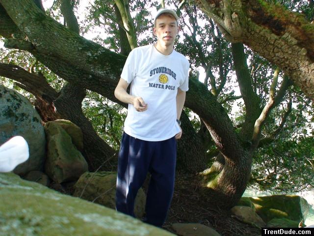 Waterpolo t-shirt, blue sweats, below a Manzanita tree