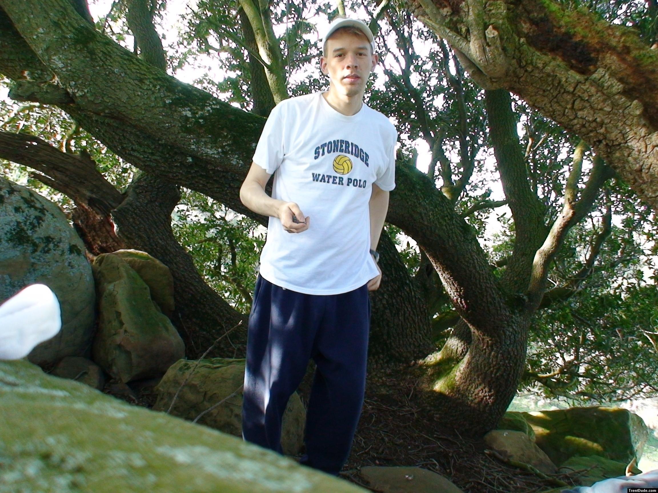 Waterpolo t-shirt, blue sweats, below a Manzanita tree