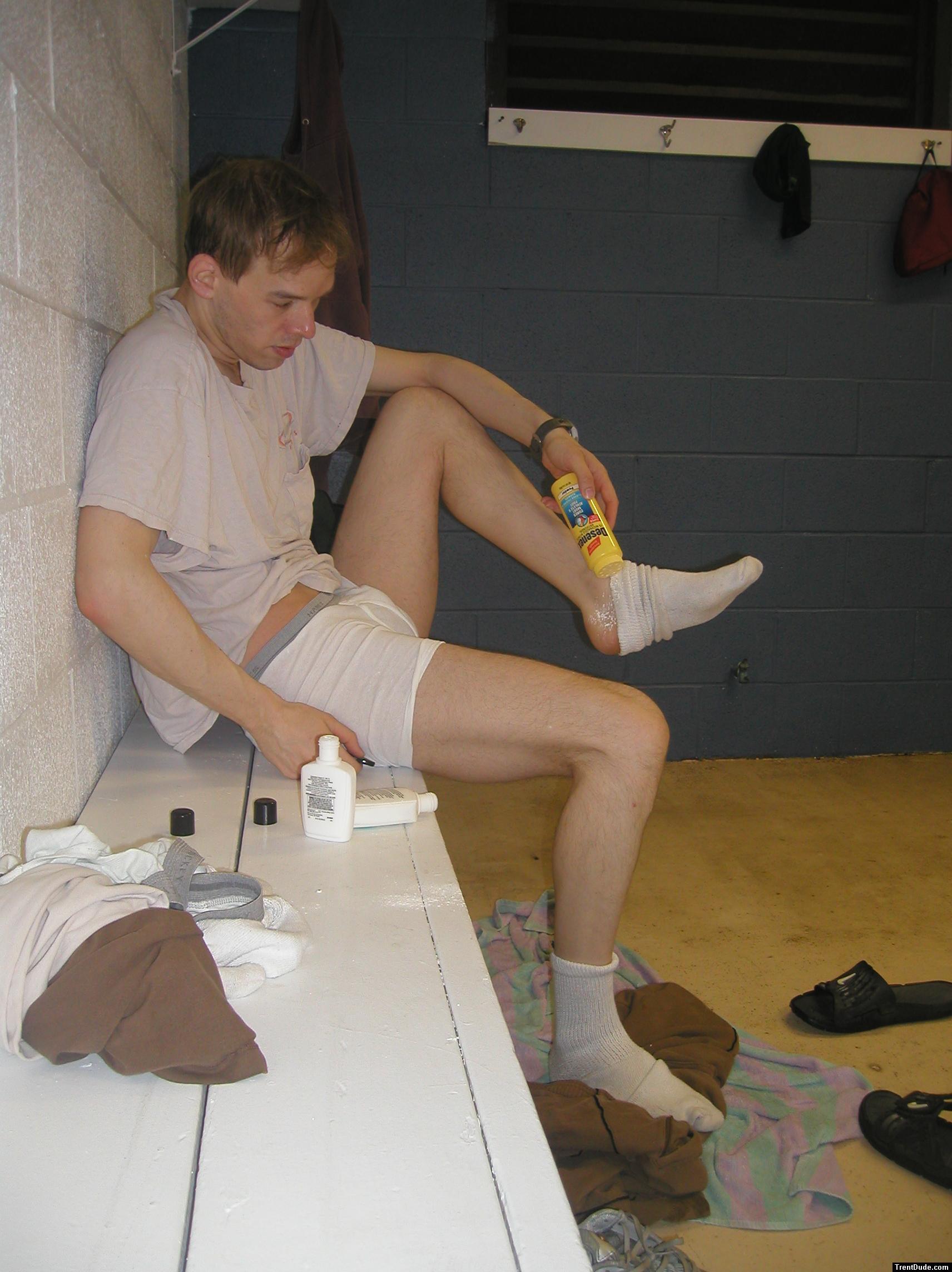 Applying Desenex Antifungal powder to his foot to prevent athlete's foot (Miconazole Nitrate)