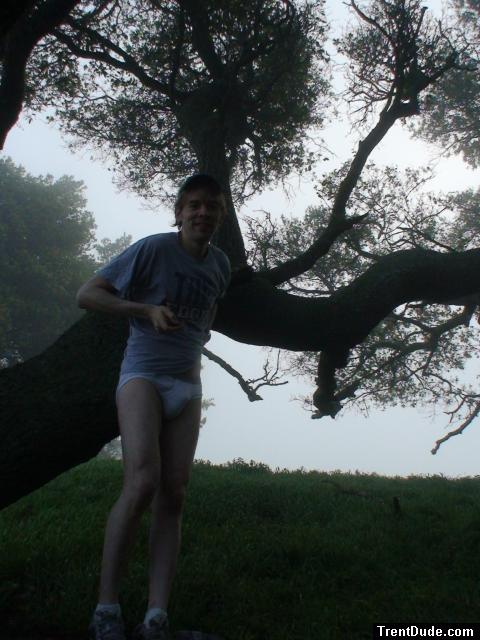Smiling in jockey briefs under a tree